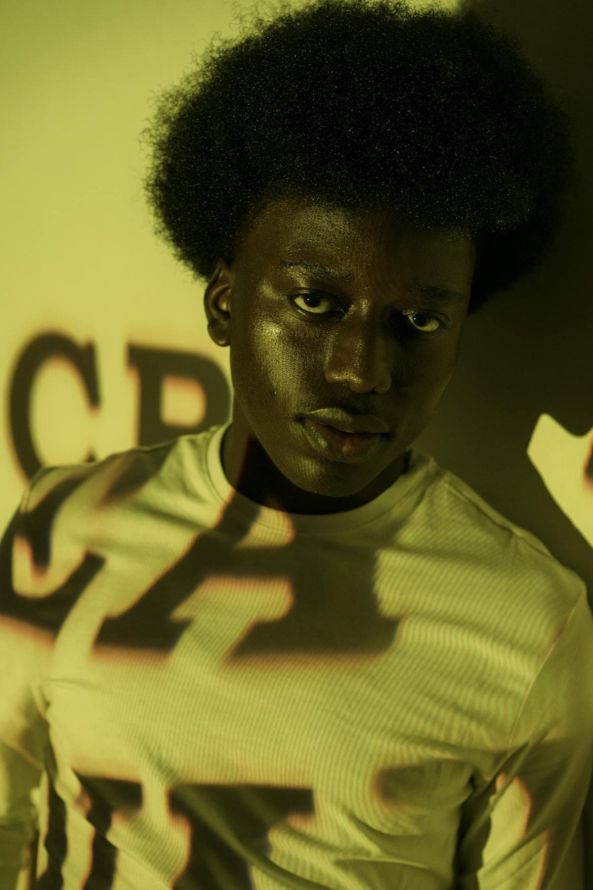 Man with afro under neon projection